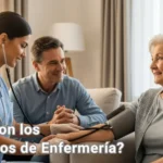 "Enfermera profesional en uniforme azul toma la presión a una adulta mayor en su casa, mientras una familiar observa con confianza y serenidad, escena cálida de cuidados de enfermería a domicilio."